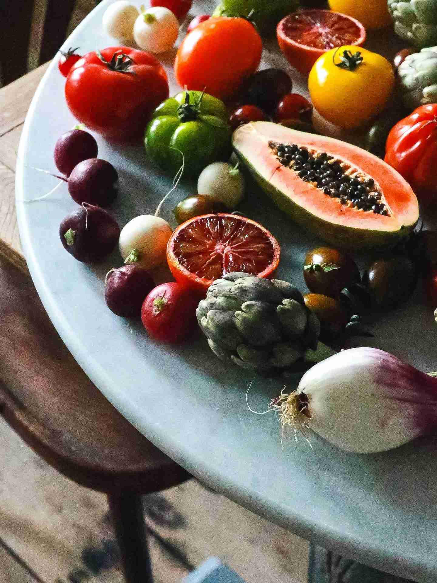 healthy foods Bunch of various ripe exotic fruits and ripe healthy vegetables placed on marble table in light kitchen during harvest season