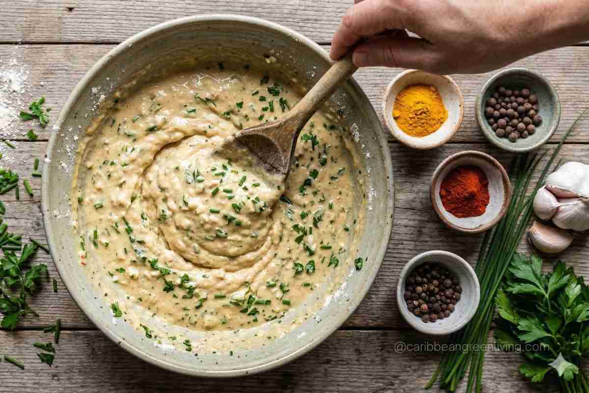 Caribbean fritter batter in a bowl with herbs