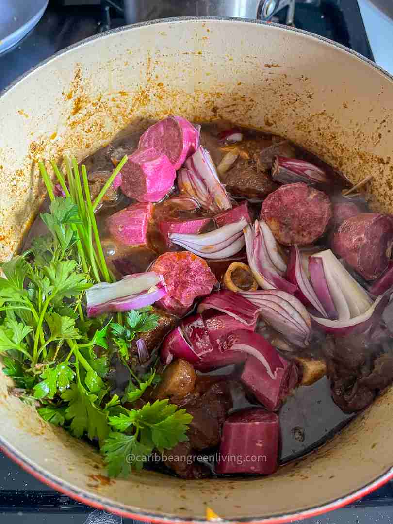 Curry Goat with Purple Sweet Potatoes in a dutch oven